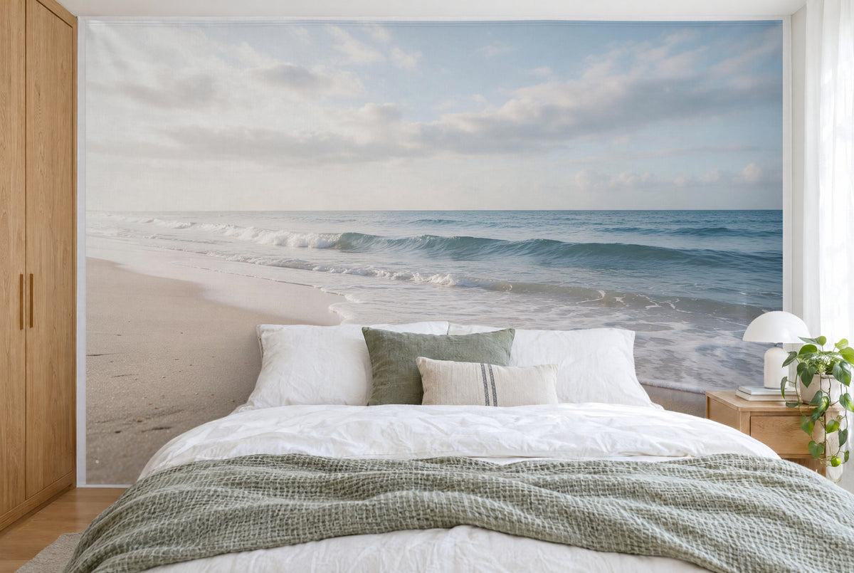 Bedruckter Stoff im XXL-Format: sanfte Wellen am Sandstrand unter Wolken, wandfüllend hinter dem Bett