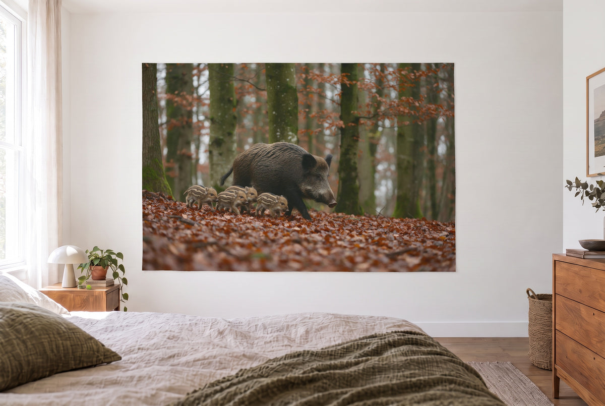 Wandtuch Wildschwein mit Frischlingen im hellen Schlafzimmer gegenüber dem Bett, rechts eine Holzkommode – Braun und Orange