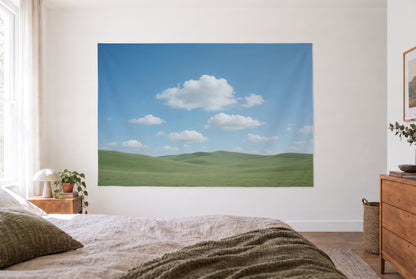 Wandtuch Blauer Wolkenhimmel über grünen Hügeln im Schlafzimmer gegenüber dem Bett, rechts Holzkommode – Blau Grün