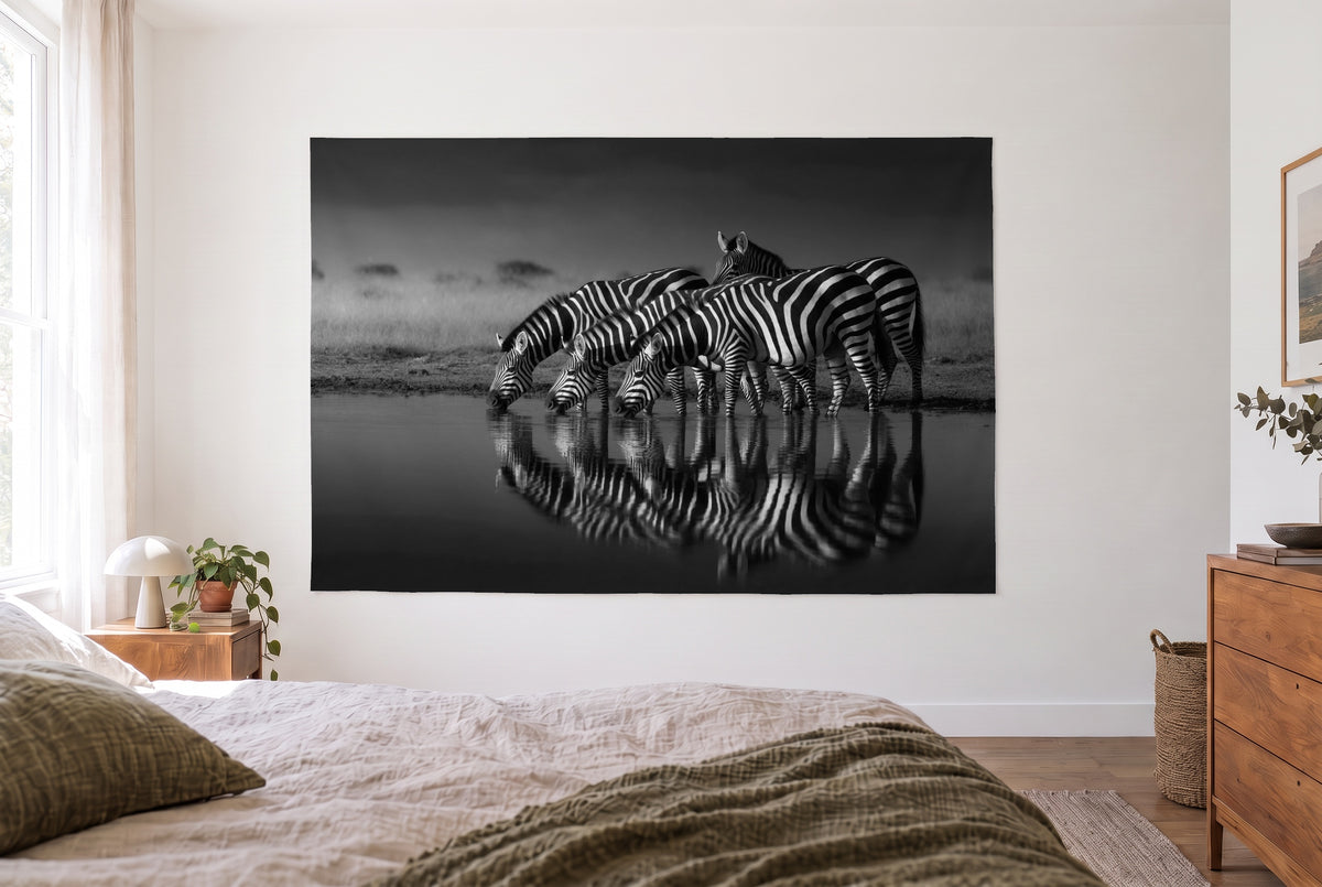 Wandtuch Zebras in Schwarz-Weiss im hellen Schlafzimmer gegenüber dem Bett, rechts eine Holzkommode – Grautöne