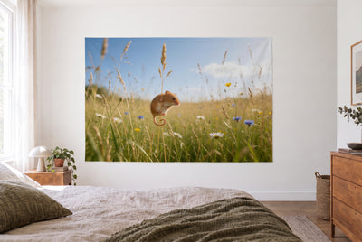Wandtuch Zwergmaus am Grashalm im hellen Schlafzimmer gegenüber dem Bett, rechts eine Holzkommode – Grün, Gelb und Blau