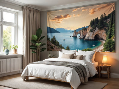 Wandtuch Felsküste mit Steinbogen und Bucht im Schlafzimmer über dem weissen Doppelbett – Abendlicht und Tannen