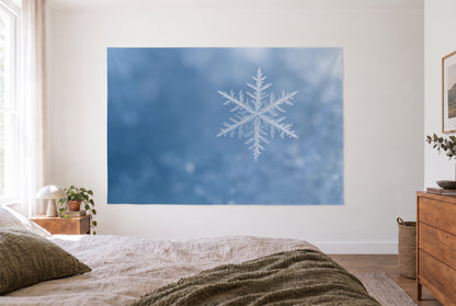 Tenture flocon de neige en gros plan dans la chambre claire face au lit, commode en bois à droite – bleu et blanc